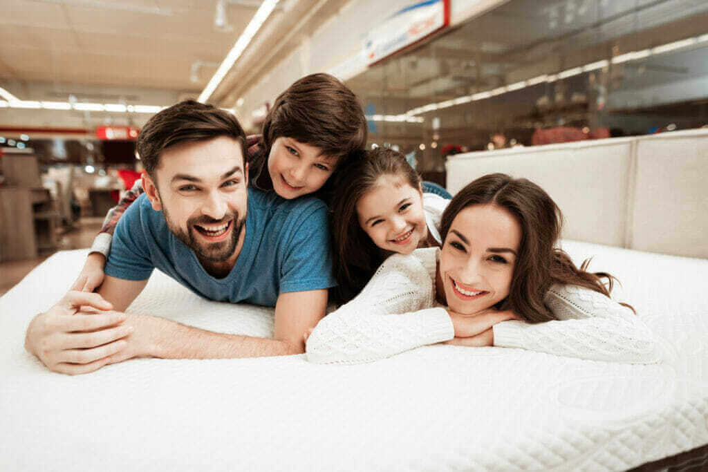 young happy family relaxing soft bed store 1