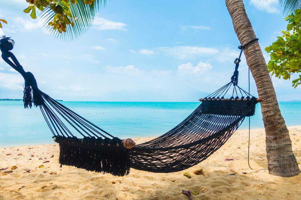 empty hammock swing around beach sea ocean with white cloud blue sky travel vacation