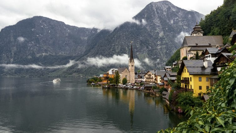 landscape hallstatt surrounded by water rocky mountains during rainy day austria